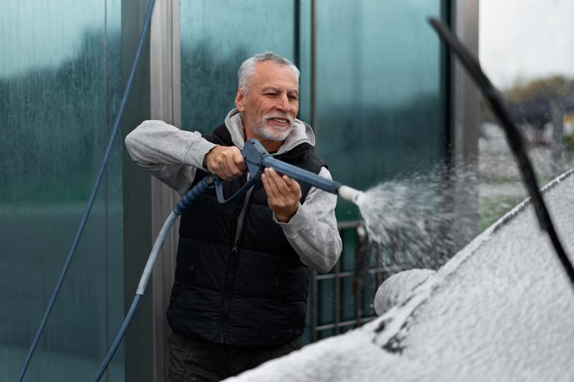 A pressure washing professional cleaning a driveway