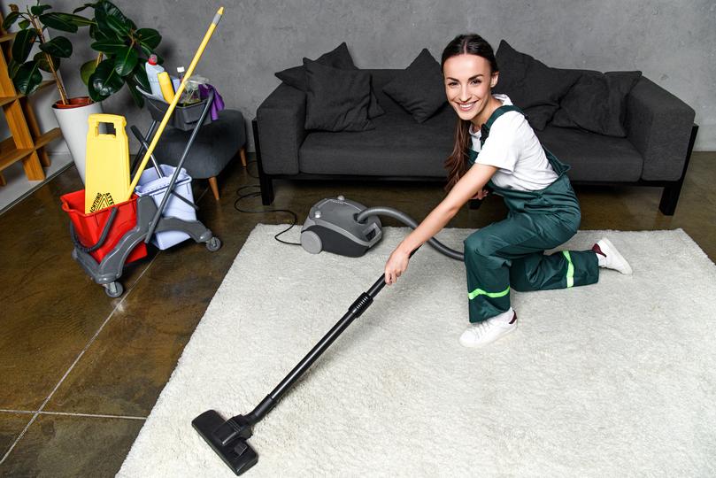 A carpet cleaning professional cleaning a carpet in a home