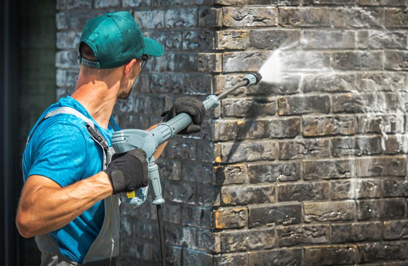 A pressure washing professional cleaning a driveway