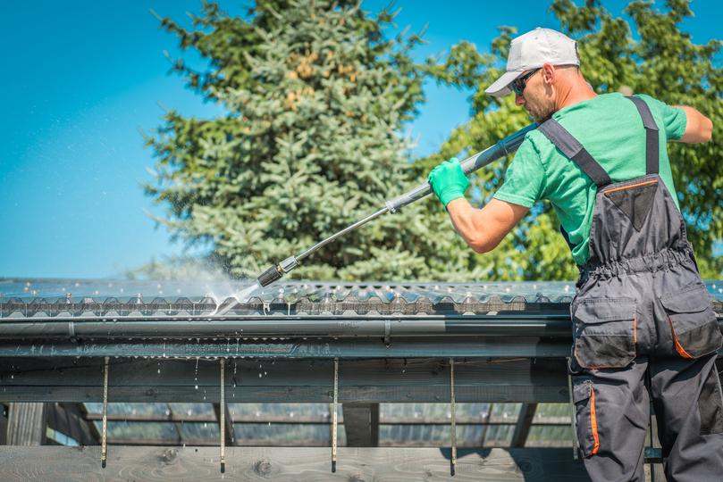 A gutter cleaning professional cleaning gutters on a house